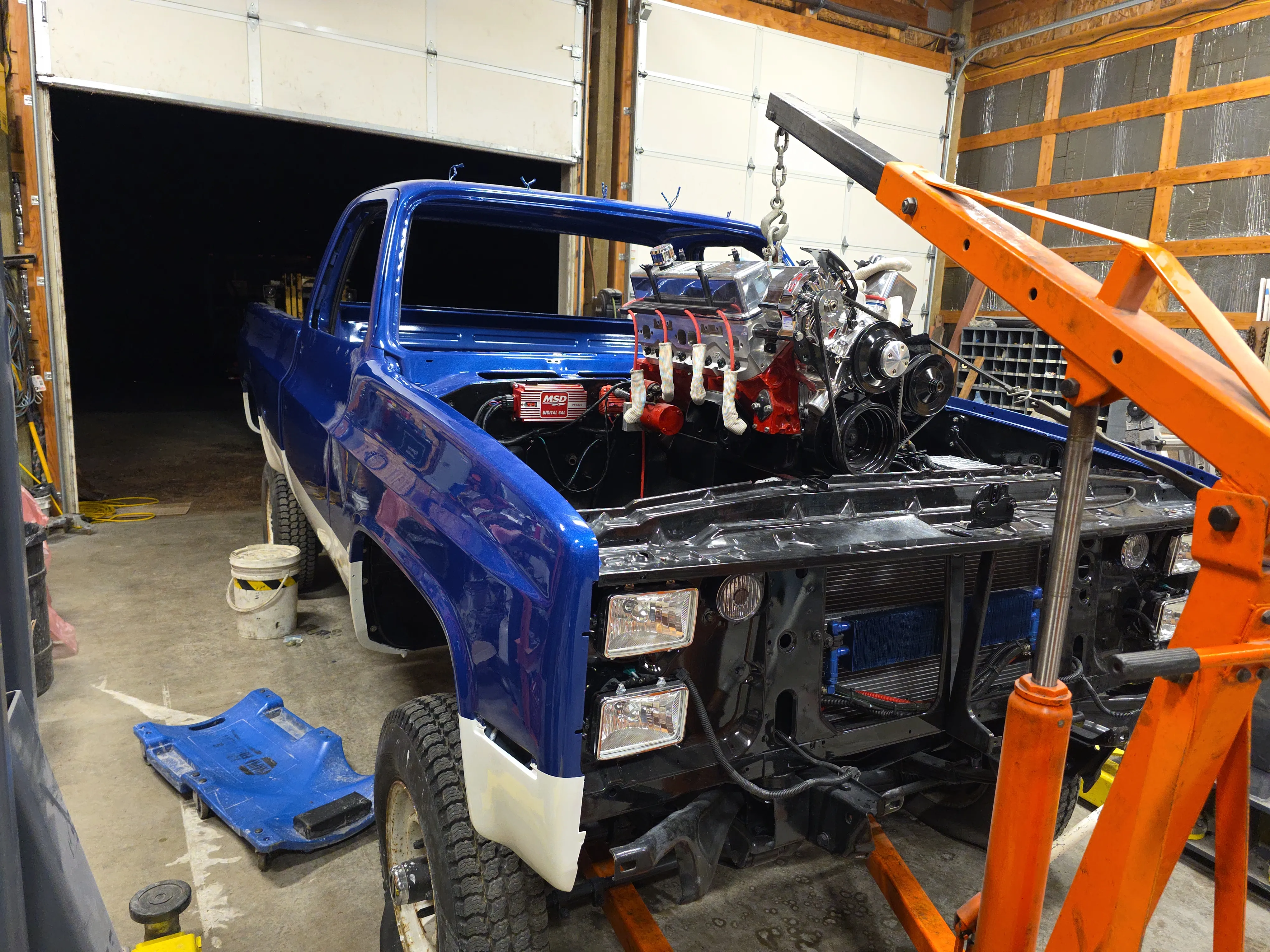 A V8 engine bay during a custom build — fresh manifold and ignition installed