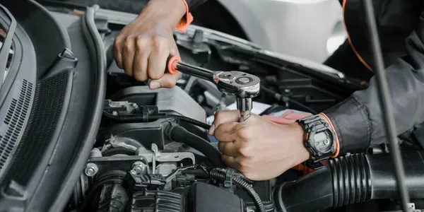 Mechanic's hands on a torque wrench during precision engine work